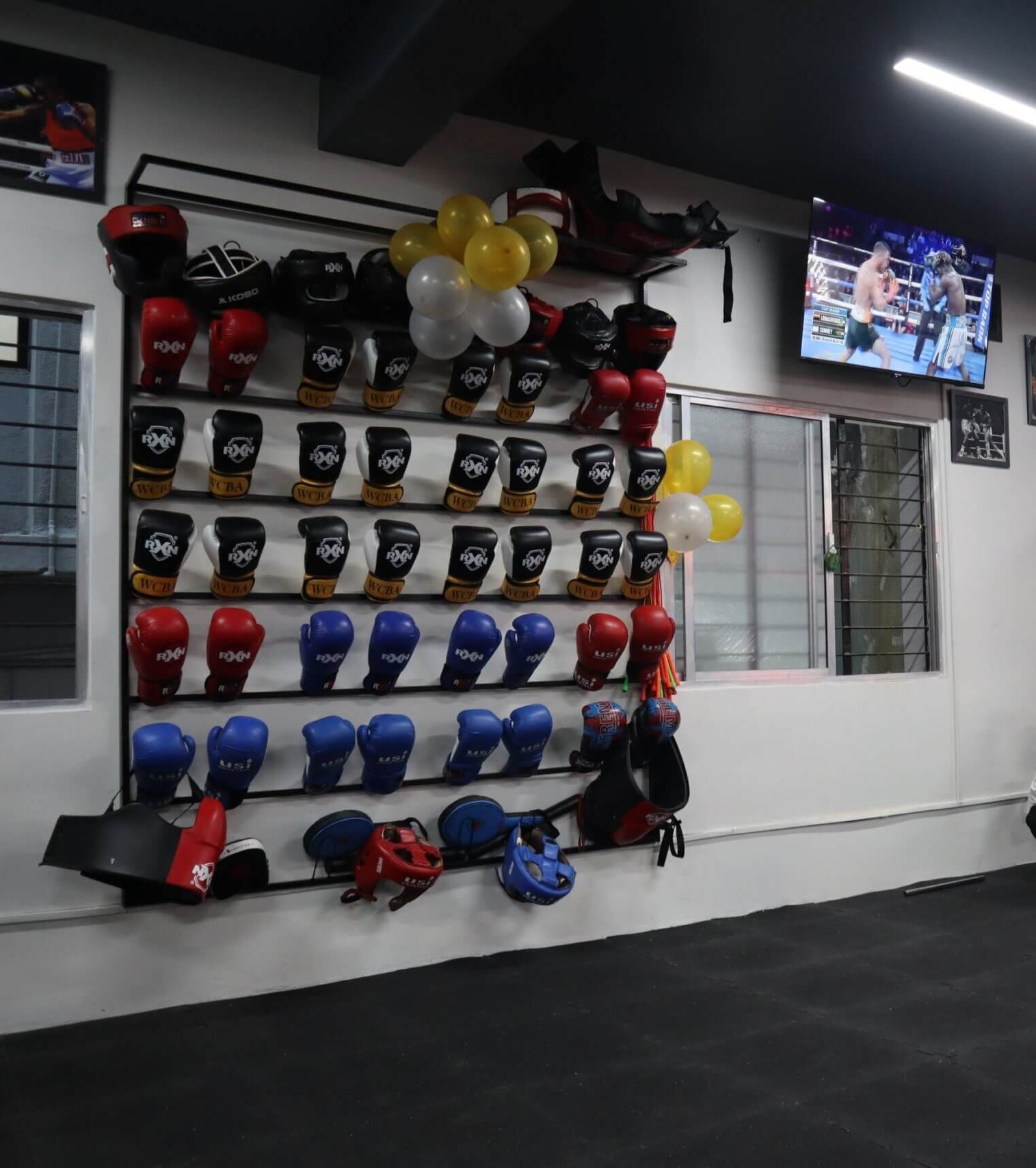 Wall of boxing gloves and safety gear at White Corner Boxing Academy for beginner and advanced boxing classes in Bangalore.
